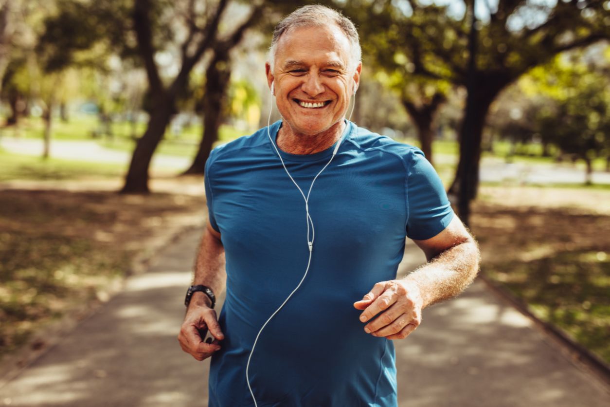 Smiling older man jogging in a park