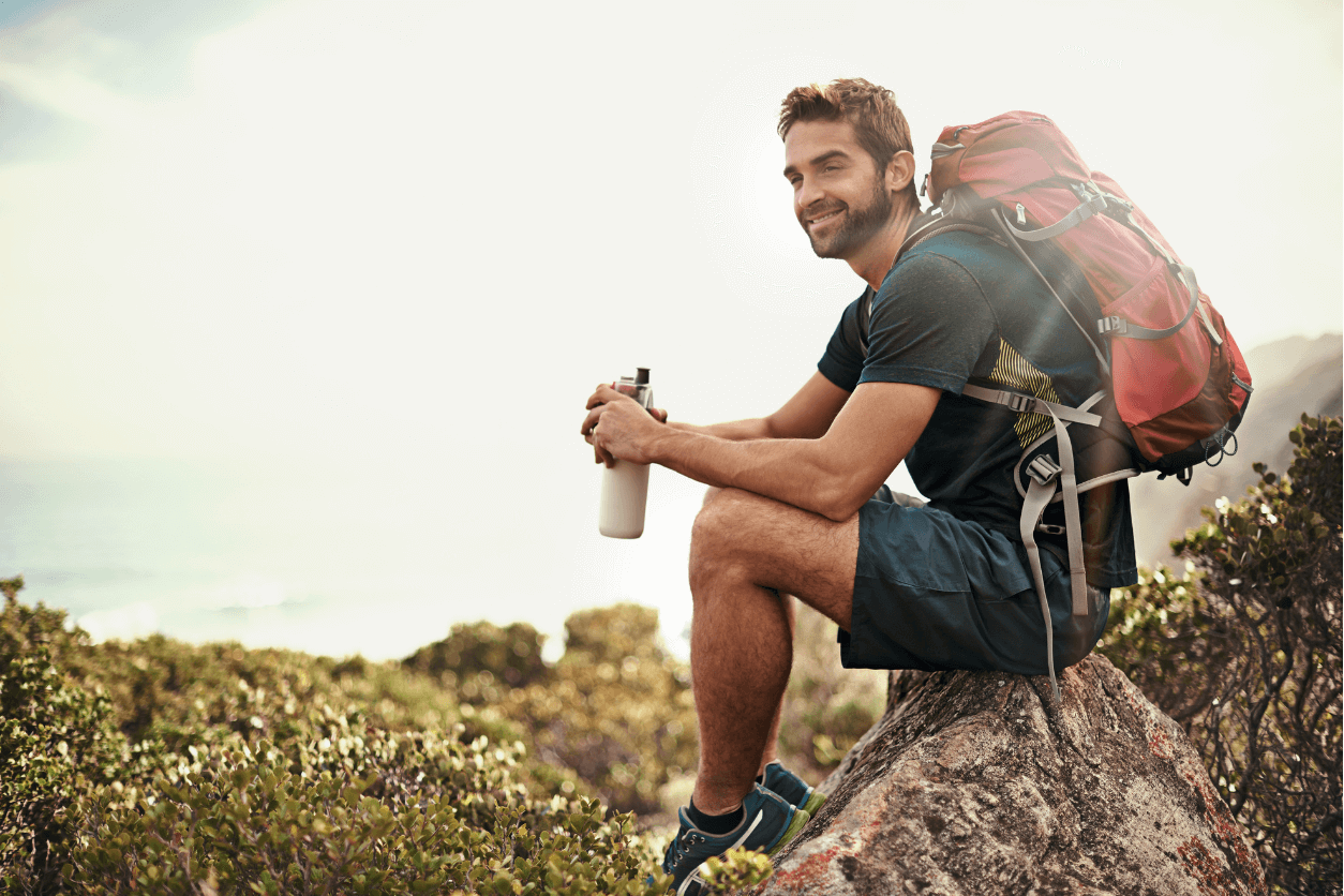 Hiker resting on a rock with a water bottle