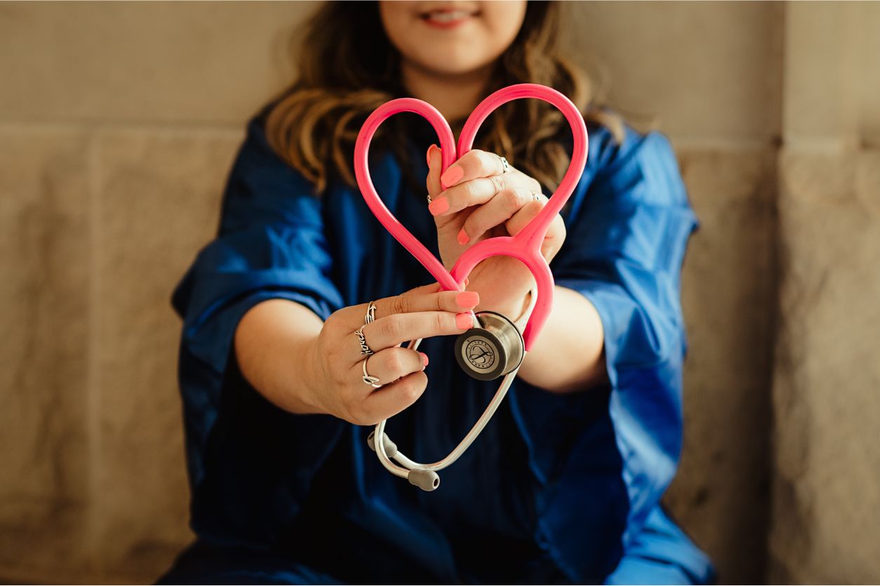 Person holding a stethoscope shaped into a heart